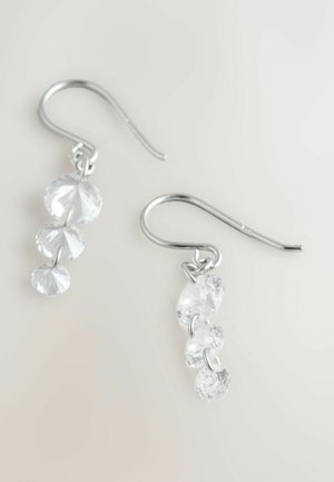 Hopeiset koukkukorvakorut, joissa on kolme kirkasta, pyöreää ja monisärmikästä jalokiveä, jotka ovat kooltaan vähenevässä järjestyksessä. Ne on asetettu vaalealle taustalle.