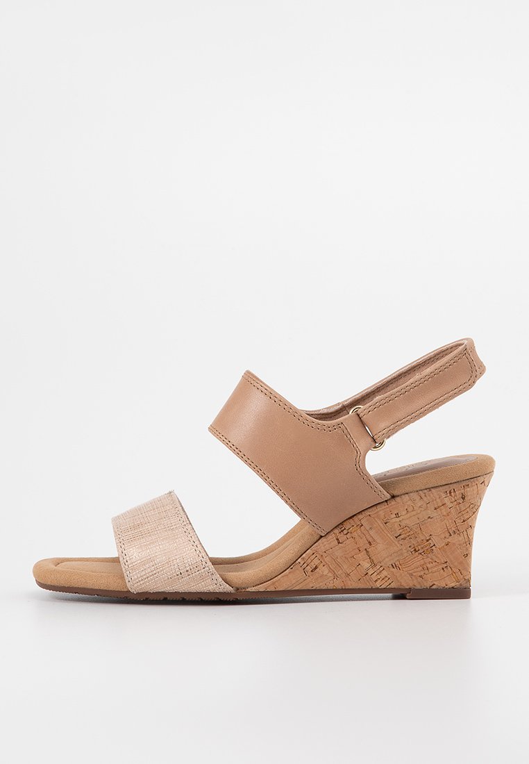 Sandalias de cuña de corcho con parte superior de cuero beige y tira de tejido texturizado. Correa de tobillo ajustable para un ajuste y soporte óptimos. Diseño de talón cerrado.