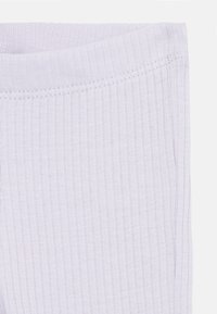 Lyse lavendelribbe leggings med myk tekstur og elastisk liv, med delikate sømdetaljer langs kantene.