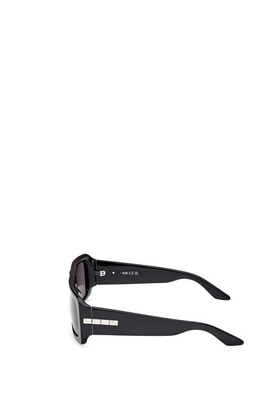 Gafas de sol de acetato negro con marco grueso, lentes rectangulares y acentos plateados en las patillas. Textura suave, diseño sin adornos.