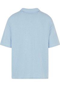 Light blue ribbed knit short-sleeve shirt with a straight cut and a classic collar. Soft texture and even stitching throughout.