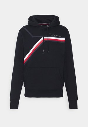 Czarna bluza z kapturem, kieszenią z przodu, sznurkami oraz ukośnymi czerwonymi, białymi i czarnymi paskami, z logo "Tommy Hilfiger" na piersi.