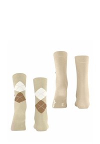 Calzini beige in esposizione; una coppia presenta un motivo argyle con diamanti bianchi e marroni. Stoffa morbida e polsini elastici visibili.