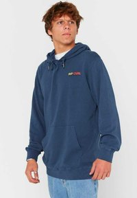 Granatowa bluza z kapturem wykonana z miękkiej tkaniny. Ma kieszeń typu kangur, kaptur ze sznurkiem oraz kolorowe logo "RIP CURL" na klatce piersiowej.