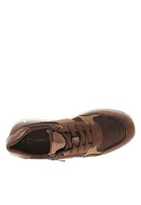 Chaussure de sport marron avec un dessus en tissu texturé, des accents synthétiques, un système de laçage et une semelle en caoutchouc. Présente un détail de logo sur la semelle intérieure.