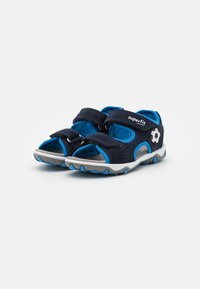 Sandalias cerradas en azul marino con tiras de Velcro, parte superior sintética, suela gris y acento de balón de fútbol. Diseño transpirable para mayor comodidad.
