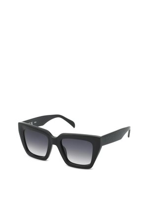 Lunettes de soleil carrées noires surdimensionnées avec verres foncés dégradés et monture épaisse, vues sous un léger angle.