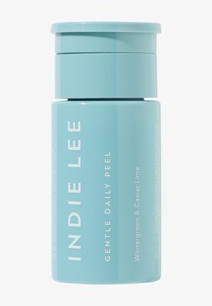 Helleblaue zylindrische Verpackung mit der Aufschrift "Indie Lee Gentle Daily Peel", versehen mit weißem Text und einer glatten Oberfläche. Der obere Deckel ist leicht gewölbt.