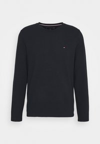 Schwarzes Langarm-T-Shirt aus strukturiertem Material, mit einem runden Halsausschnitt und einem kleinen dreifarbigen Logo auf der Brust.