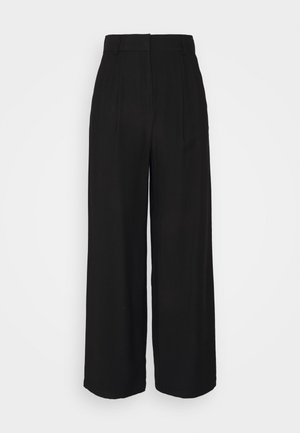 Pantalon taille haute à jambes larges en tissu noir. Présente des plis à l'avant et une ceinture lisse. Confectionné pour une coupe décontractée.