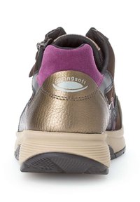 Bruine en gouden sportschoen met een getextureerde leren bovenkant, een paarse suède kraag en een gevoerde beige zool. Logo gedrukt op de achterkant.