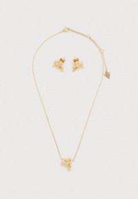 Σετ κοσμημάτων σε χρυσό τόνο με κολιέ με μενταγιόν σε σχήμα καρδιάς και ταίριαστα καρφωτά σκουλαρίκια καρδιάς με κομψές, λείες επιφάνειες.