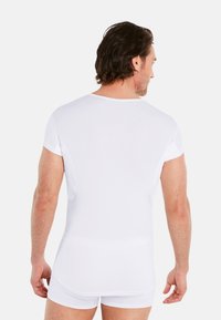 White short-sleeve T-shirt made from soft fabric, featuring a crew neckline and a fitted design, displayed from the back.