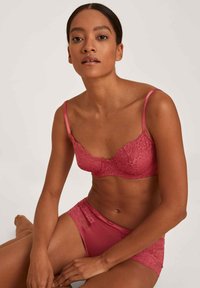 Kanten bh en slipset in dieproze; met bloempatronen, satijnen banden en een semi-doorzichtige afwerking. Getextureerd en ontworpen voor comfort.