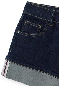 Gonna in denim con un lavaggio blu scuro, orlo azzurro chiaro a contrasto e tre strisce rosse e bianche. Include una piccola tasca posteriore.