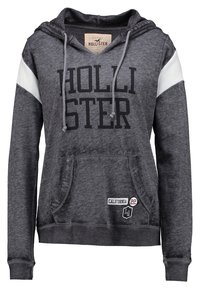 Tmavě šedá mikina s klokaní kapsou, bílými akcenty na ramenou a výrazným logem "HOLLISTER". Obsahuje stahovací šňůrky a žebrované manžety.