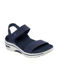 Infradito blu navy con fasce in mesh, plantare imbottito e suola bianca con motivo testurizzato. Fascetta posteriore regolabile per una vestibilità ottimale.