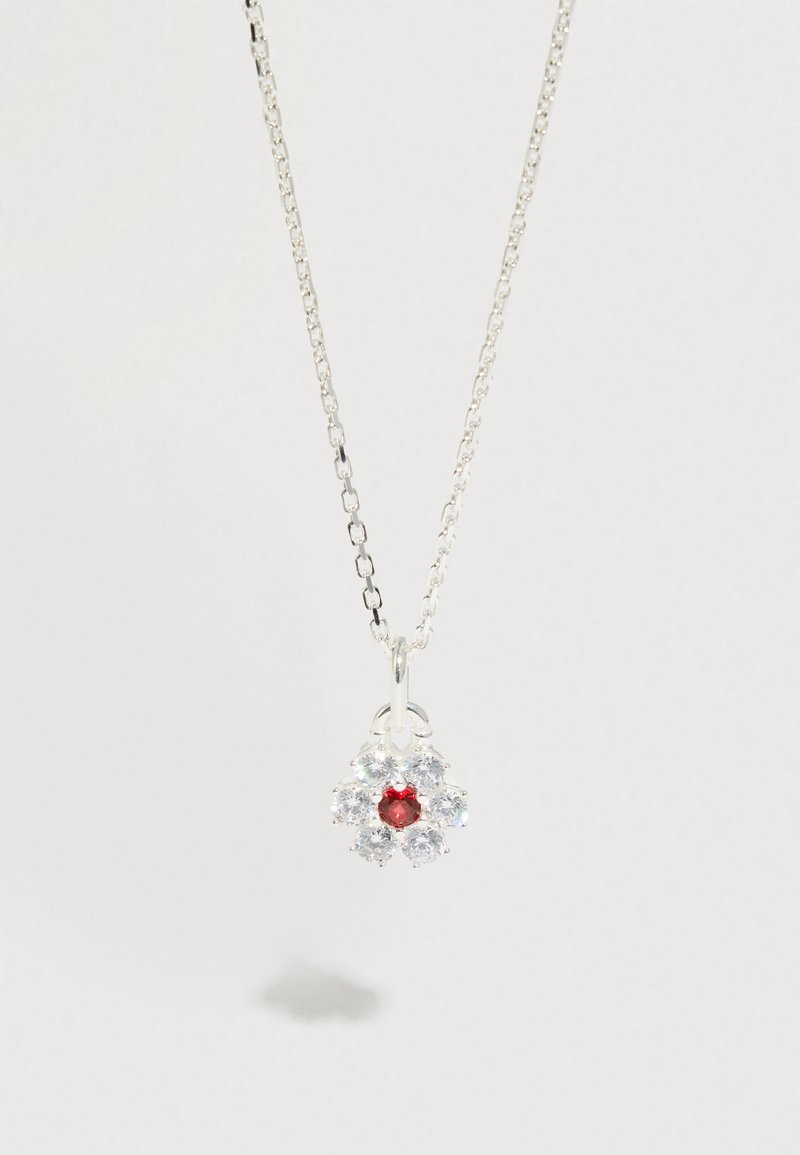 Collier en argent avec un pendentif en forme de fleur, orné d'une pierre rouge centrale entourée de pierres claires circulaires, maillons de chaîne lisses.