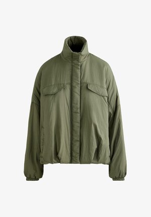 Giacca imbottita verde oliva con collo alto, maniche lunghe con polsini elastici, due tasche a patta sul petto e chiusura anteriore a scomparsa.