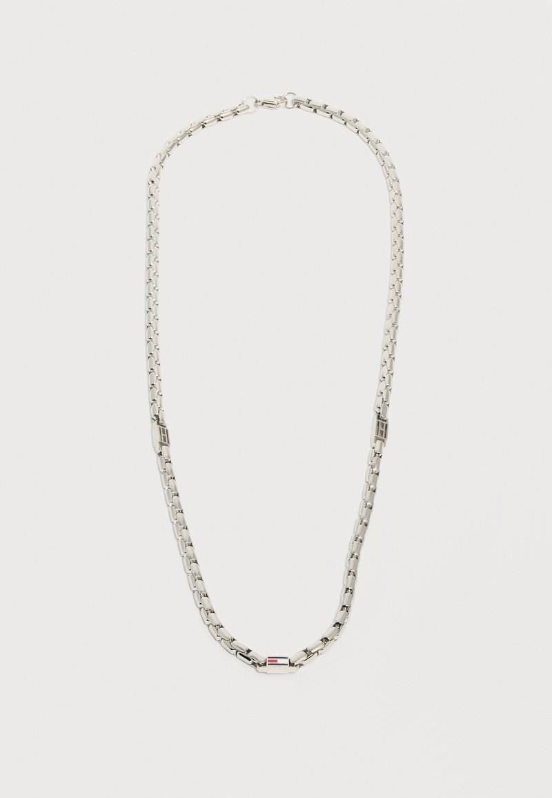 Ασημένια αλυσίδα με ορθογώνιο κούμπωμα που φέρει μια μικρή ορθογώνια λεπτομέρεια σε κόκκινο, λευκό και μαύρο χρώμα.