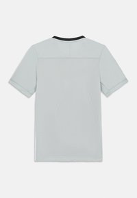 Šviesiai pilkas trumpomis rankovėmis marškinėliai su vientisa viršutine dalimi ir tekstūruota tinklelio apatine dalimi. Juoda apvalios apykaklės detalė. Be siūlių dizainas.