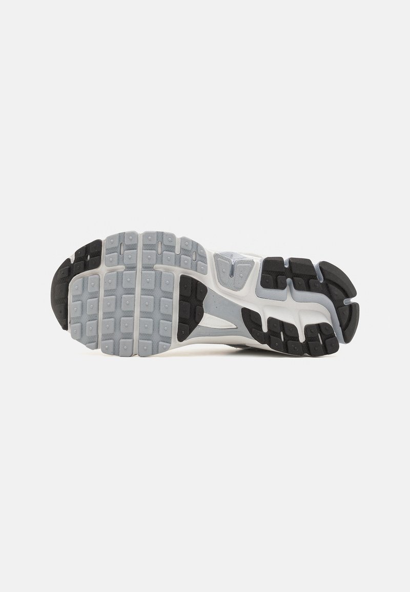 Schoenondergrond met een rubberen mengsel en een gemarmerd patroon, voornamelijk grijs met zwarte accenten, ontworpen voor grip en duurzaamheid.