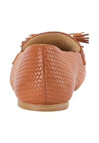 Pantof cu mocasin din piele maro, cu un model texturat țesut, talpă plată și ciucuri decorativi la călcâi. Fără hardware vizibil.