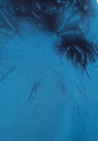 Niebieska tkanina z drobnym pionowym żebrowaniem i ciemniejszymi niebieskimi wzorami tie-dye, tworzącymi abstrakcyjne, nieregularne kształty i cienie.