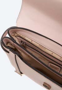 Borsa in finta pelle rosa chiaro con due scomparti, una tasca con zip e un accento in metallo con logo. La fodera presenta un motivo con marchio.