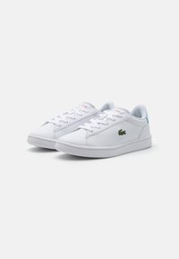 Sneaker bianche con tomaia in pelle liscia, punta arrotondata e suola in gomma. Presentano lacci, un logo di coccodrillo ricamato verde e dettagli blu.