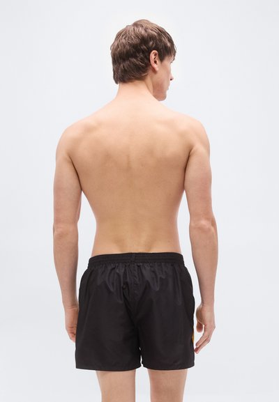 Μαύρα μαγιό σορτς από ελαφρύ υλικό, με ελαστική μέση και απλό σχέδιο, που φαίνεται από την πίσω πλευρά.