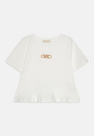 T-shirt blanc à manches courtes avec un ourlet en peplum, présentant un logo de broche de sécurité en ton doré orné de strass à l'avant.