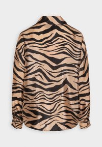 Light tan button-up shirt with a shiny finish, featuring bold black tiger stripes. Long sleeves with button cuffs and a standard collar.