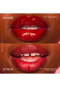 Gros plan sur des lèvres avec une brillance brillante rouge vif sur le dessus et une finition tache rouge hydratée en dessous, montrant les dents et la texture naturelle de la peau.