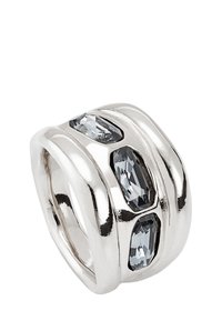 Anillo de plata con tres acentos de piedras grises alargadas. Presenta secciones suaves y curvadas que crean un efecto en capas. Acabado pulido.