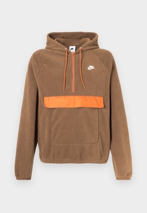 Bruine fleece hoodie met een oranje voorvak en ritssluiting. Voorzien van een capuchon en een klein wit Nike-logo op de borst. Zachte textuur.