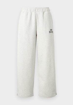 Heledat hallid dressipüksid, mis on valmistatud pehmest materjalist, varustatud elastse vöökohaga ja väikese musta "New Balance" logoga küljel.