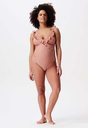 Eénstuk zwempak in gedempt roze, met rimpelaccenten langs de halslijn en een getailleerde silhoutte met zijwaartse plooien. Zacht, rekbaar materiaal.