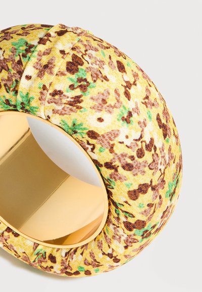 Κίτρινο βραχιόλι χειροπέδα καλυμμένο με ύφασμα με καφέ και πράσινο αφηρημένο ανθικό μοτίβο και λαμπερή χρυσή εσωτερική επιφάνεια.