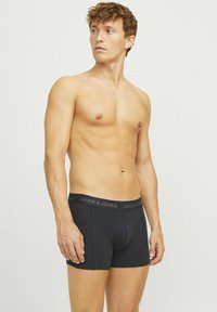 Zwarte boxershorts met een zachte textuur, voorzien van een logo op de tailleband in donkergroen. Het ontwerp heeft een aansluitende pasvorm met een voorvak.