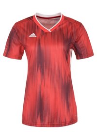 Röd kortärmad fotbollsdräkt med V-hals och ett gradientprickmönster, med vita accenter och Adidas-logotyp på övre vänstra sidan.