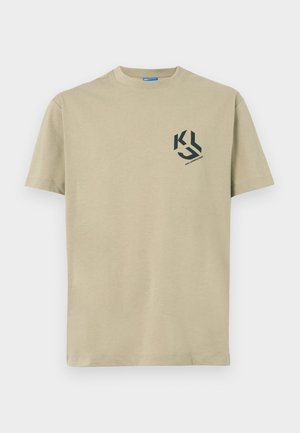 Šviesiai kreminės spalvos medvilnės marškinėliai trumpomis rankovėmis ir apvaliu iškirpimu, su juodu grafiniu logotipu kairėje krūtinės pusėje.