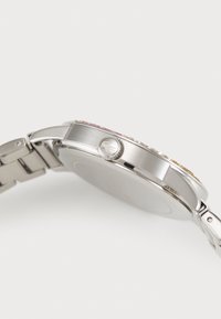Reloj de acero inoxidable plateado con una caja redonda, acentos decorativos de colores en el bisel y una corona texturizada. Estilo de pulsera de eslabones metálicos.