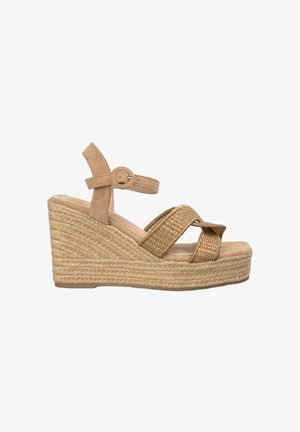 Sandales à talons compensés beiges avec un talon en jute tissé, des brides en suedine et une boucle à la cheville. Présente un design croisé à l'avant. Texture douce.