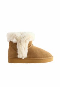 Tanfarbene Wildlederstiefel mit einem weichen weißen Fellkragen, abgerundeter Zehenform und flacher Sohle. Sie zeichnen sich durch eine glatte Textur mit minimalen Nähdetails aus.