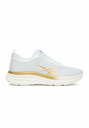 Witte sportschoen met gouden accenten, gewatteerde witte zool en zijlogo, getoond vanaf de linkerkant op een effen achtergrond.
