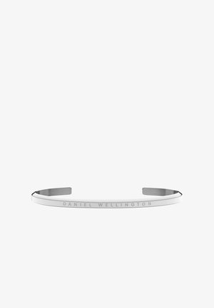 Silbernes offenes Manschettenarmband mit der Gravur "Daniel Wellington" auf einem glatten, schmalen Metallband.