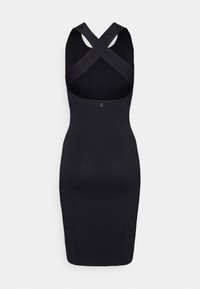 Robe noire ajustée en maille côtelée avec un col montant et des bretelles croisées dans le dos. Présente une texture lisse et un petit logo au dos.