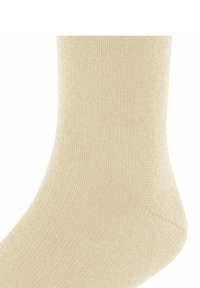 Beżowa skarpetka wykonana z miękkiego materiału dzianinowego. Posiada ryflowaną teksturę i gładki szew w okolicy palców. Wysokość do kostki, z zaokrąglonym obcasem.