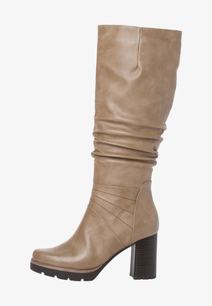 Wysoki beżowy skórzany but z marszczoną cholewką, ozdobnym przeszyciem na kostce i masywnym ciemnobrązowym klockowym obcasem.